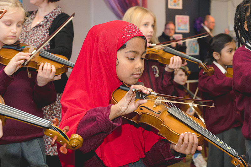 Moyderwell Mercy National School students playing violin with teacher