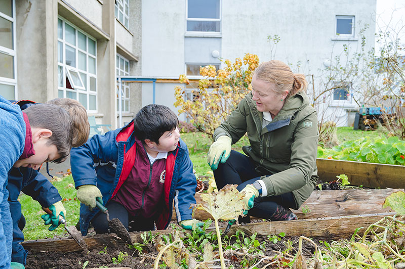 Moyderwell Mercy National School students and teacher digging in school garden